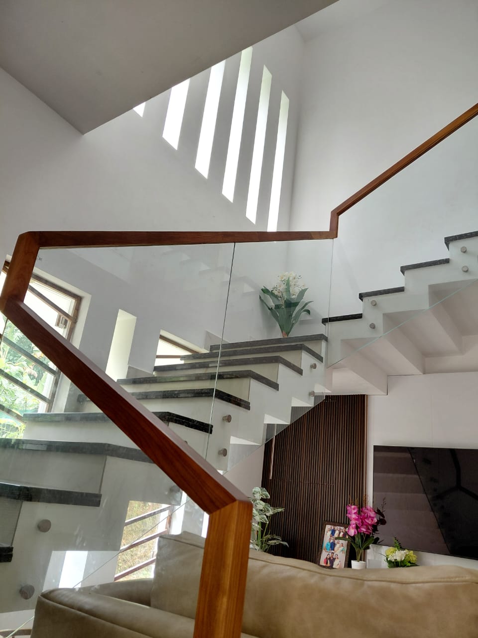 Staircase with glass panels and wooden rail